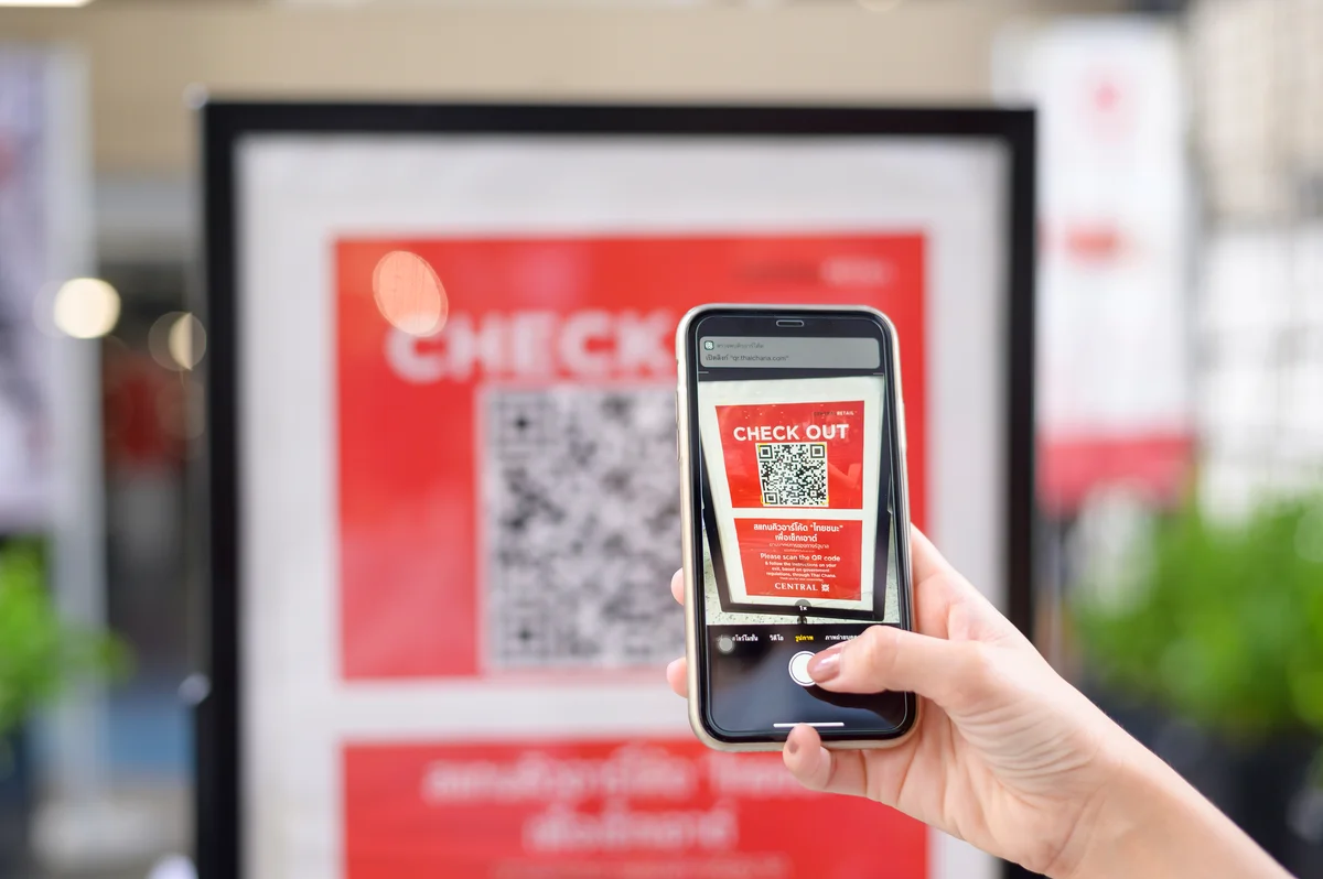 Person scanning a QR code from a digital advertising display